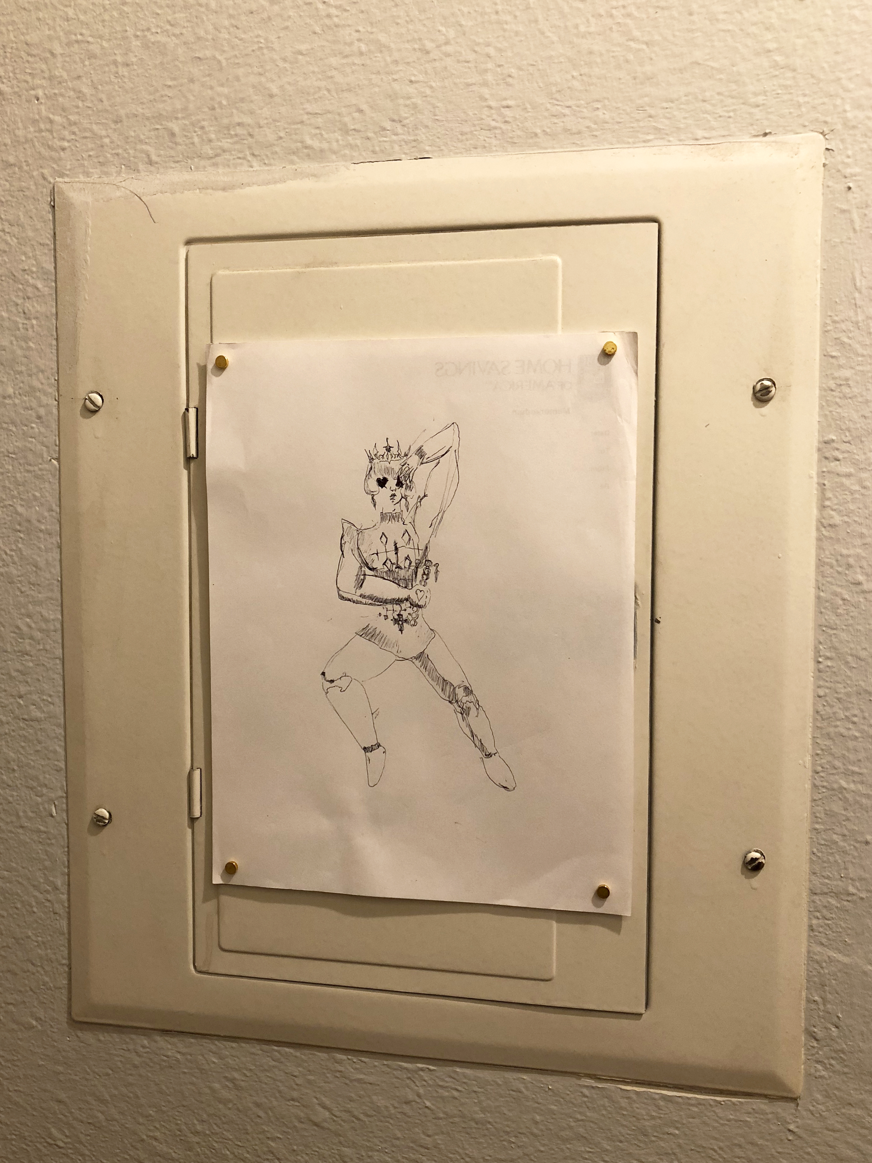Drawing of a stylized prince character on white paper hung on an electrical box